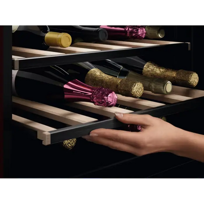 Hand opening a wine cooler with bottles inside